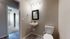 Charming bathroom with modern fixtures, elegant vanity mirror, and soft ambient lighting, adjacent to a cozy carpeted bedroom.