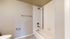 Modern bathroom featuring a sleek white bathtub, elegant tile accents, and minimalist fixtures.
