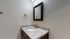 Elegant bathroom with a sleek granite countertop, modern sink, and stylish mirror, ideal for a contemporary apartment.