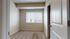 Inviting bedroom with plush carpet and large window offering natural light and serene views.