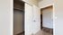 Inviting apartment interior featuring a spacious closet and elegant white doors, with a glimpse of stylish flooring in the hallway.