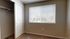 Bright bedroom with large window, plush carpet, and open closet, offering cozy living in an inviting space.