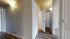 Inviting apartment hallway with elegant wooden flooring and soft ambient lighting, leading to multiple spacious rooms.