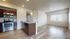 Contemporary open-plan kitchen and living area with sleek hardwood floors, granite countertops, and elegant cabinetry.