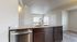 Modern open-plan kitchen featuring stylish granite countertops and stainless steel appliances, with natural light streaming through large windows.