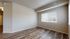 Bright and spacious room with large windows and elegant wood-style flooring, creating an inviting and airy atmosphere.