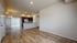 Inviting open-concept living room with elegant hardwood floors, modern kitchen with stainless steel appliances, and abundant natural light.