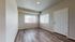 Bright and inviting room with elegant wood flooring, large windows, and a sleek white door.