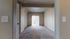Inviting, sunlit room with plush carpeting and elegant neutral walls, featuring sliding glass doors leading to a serene outdoor view.
