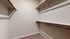 Spacious walk-in closet with ample shelving and hanging space, perfect for organized storage.