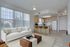 Bright and airy open-plan living area with modern kitchen and cozy seating, featuring large windows with scenic views.