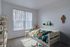 Cozy child's bedroom with playful star lights, vibrant bedding, and natural light through large windows.