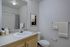 Modern bathroom with sleek fixtures, a large mirror, stylish artwork, and a vibrant shower curtain creating a serene atmosphere.