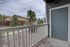 Charming patio view with wooden railing, surrounded by lush greenery and a picturesque neighborhood backdrop.