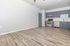 Bright and modern kitchen with sleek gray cabinets, stainless steel appliances, and stylish wood-style flooring.