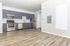 Modern kitchen with sleek grey cabinets, stainless steel appliances, and elegant hardwood flooring.