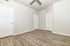 Spacious bedroom with elegant wood flooring and crisp white walls, offering a bright and airy ambiance.