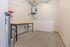 Modern utility room featuring sleek concrete flooring, a spacious workbench, and a state-of-the-art water heater.