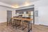 Modern kitchen with sleek cabinets, stainless steel appliances, and a stylish wooden dining table with chairs on elegant hardwood floors.