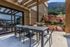 Charming outdoor patio with sleek dining set and scenic mountain backdrop, perfect for al fresco dining and relaxation.