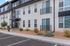Modern apartment complex exterior with sleek black and white design, featuring large windows and landscaped surroundings. Ideal urban living space.