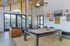 Luxe clubhouse interior with a chic pool table, stylish seating, and vibrant decor, offering sweeping views through large glass doors.