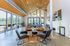 Contemporary open-concept living space featuring high ceilings, modern seating, and expansive windows with scenic outdoor views.