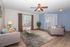 Contemporary living room with stylish gray sofas, vibrant throw pillows, a chic glass coffee table, and warm-toned hardwood flooring.