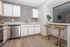 Bright and inviting kitchen with modern stainless steel appliances, sleek countertops, and a cozy breakfast bar featuring stylish wooden stools.