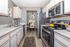 Modern kitchen with stainless steel appliances, sleek countertops, and a cozy dining area view, perfect for stylish living.