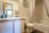 Chic bathroom with modern fixtures, elegant vanity, and charming shower curtain for a cozy and inviting feel.