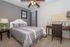 Charming bedroom with elegant gray accents, cozy bed, stylish desk area, and serene decor.