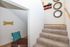 Inviting staircase adorned with unique circular wall mirrors and cozy dog nook, highlighting comfort and style.