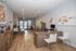 Chic office space with modern wooden flooring, stylish desks, and vibrant abstract wall art, perfect for a creative workspace.