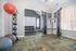 Modern fitness center featuring weight training equipment, colorful exercise balls, and a bright, spacious design.