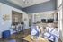 Bright and inviting open-concept living space featuring modern decor, cozy seating area, and a sleek kitchen bar with stools. Perfect for relaxation and entertaining.