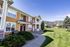 Charming apartment exterior with a vibrant color palette, lush landscaping, and stunning mountain views in the background.