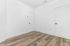 Bright and inviting room with elegant wooden flooring and pristine white walls, perfect for customization.