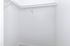 Spacious walk-in closet with sleek white walls and ample hanging space, perfect for organized storage.