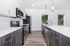 Sleek modern kitchen with stainless steel appliances, elegant white countertops, and chic pendant lighting.