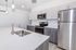 Modern kitchen with sleek stainless steel appliances, elegant pendant lighting, and spacious white countertops.