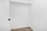 Spacious walk-in closet with sleek white walls and modern flooring, perfect for ample storage.