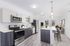 Modern kitchen and living area with sleek cabinetry, stainless steel appliances, and a spacious island with bar seating, offering a stylish open-concept design.