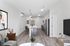 Modern open-concept apartment featuring a sleek kitchen with stainless steel appliances, elegant island with bar stools, cozy living area with chic decor, and stylish lighting fixtures.