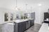 Modern kitchen with sleek dark cabinets, stainless steel appliances, and a bright open layout leading to a scenic balcony view.