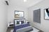 Modern bedroom with chic abstract artwork, plush bedding, and sleek blinds creating a cozy, stylish ambiance.