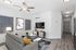 Modern living room with sleek design featuring a cozy gray sofa, stylish coffee table, and wall-mounted TV, complemented by minimalist decor and warm lighting.