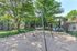 Inviting apartment playground surrounded by lush greenery, featuring swings and climbing structures for family enjoyment.