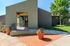 Charming modern apartment entrance with lush greenery and vibrant flower pots, inviting ambiance.