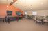 Inviting living area with elegant furniture against a vibrant accent wall, featuring modern lighting and comfortable seating for social gatherings.